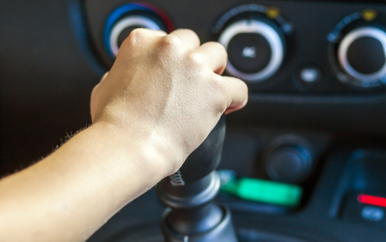 Driver hand shifting gear shift knob manually, selective focus